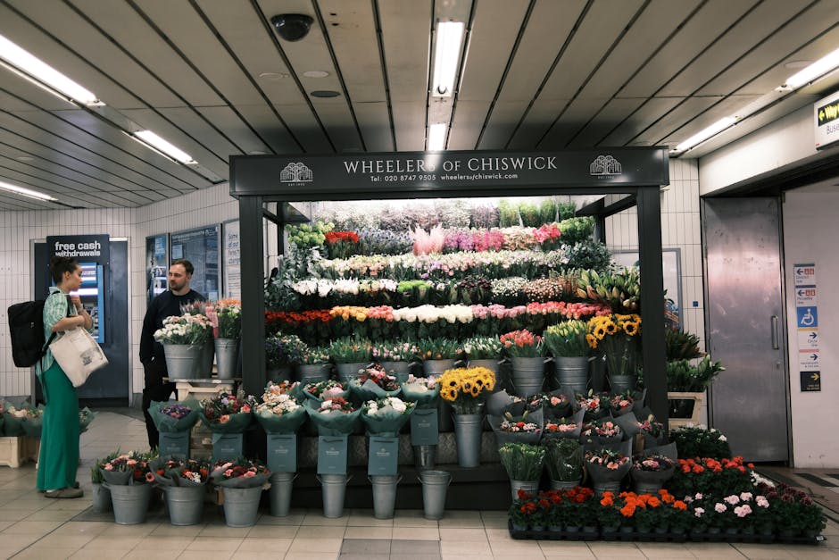 A vibrant flower display at Wheeler of Chiswick in an underground station setting, featuring an arrangement of fresh flowers including roses, tulips, and daisies in shades of pink, red, yellow, and wh